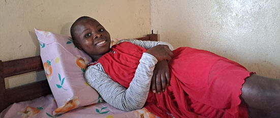 A smiling girl laying in her bed