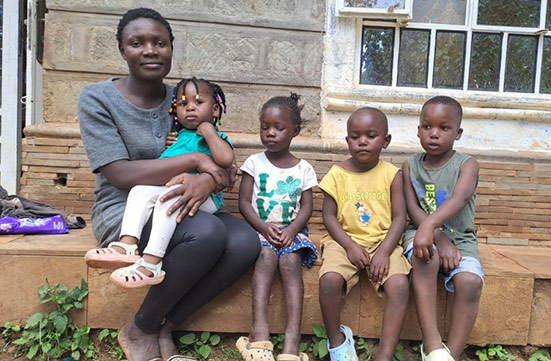 A woman sitting with four children