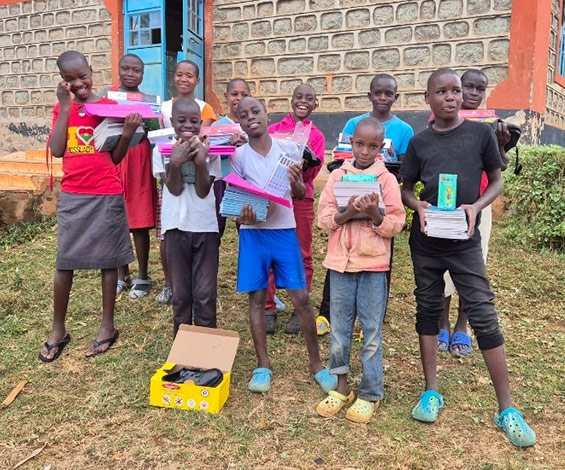 A group of smiling children receiving supplies