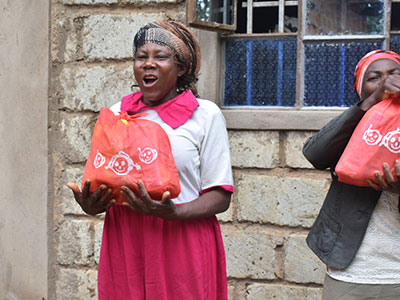 A widow smiling with her bag of Christmas goods