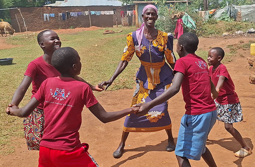 A smiling caregiver Ezina playing a game with her children